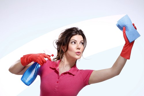 Professional cleaner restoring bright glass in Belgravia